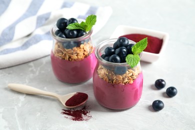 Image of Tasty dessert with acai smoothie, granola and berries on marble table