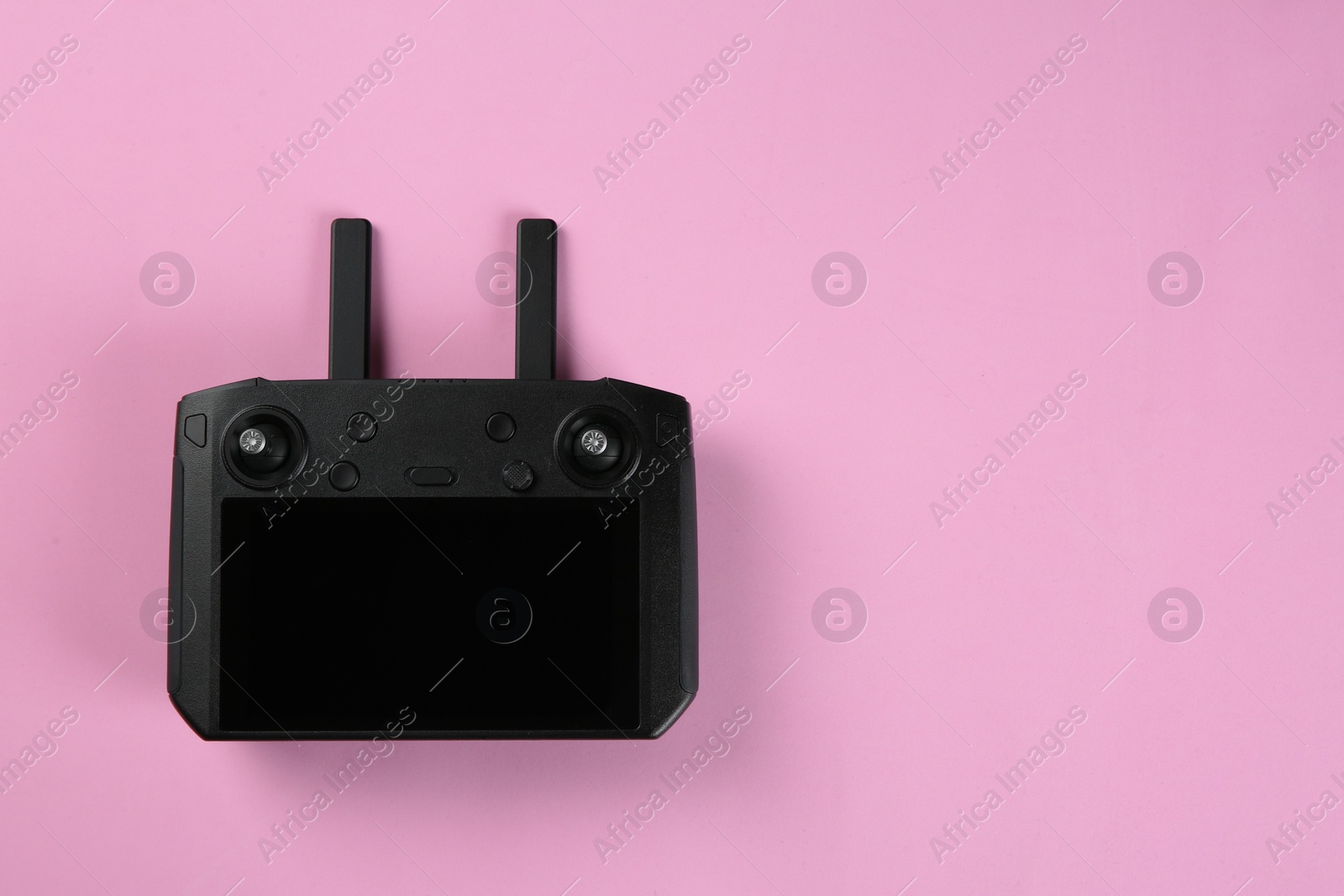 Photo of New modern drone controller on pink background, top view. Space for text