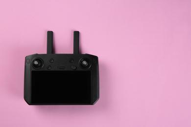 Photo of New modern drone controller on pink background, top view. Space for text