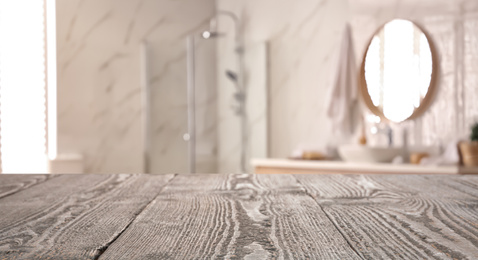 Image of Empty wooden table and blurred view of stylish bathroom interior