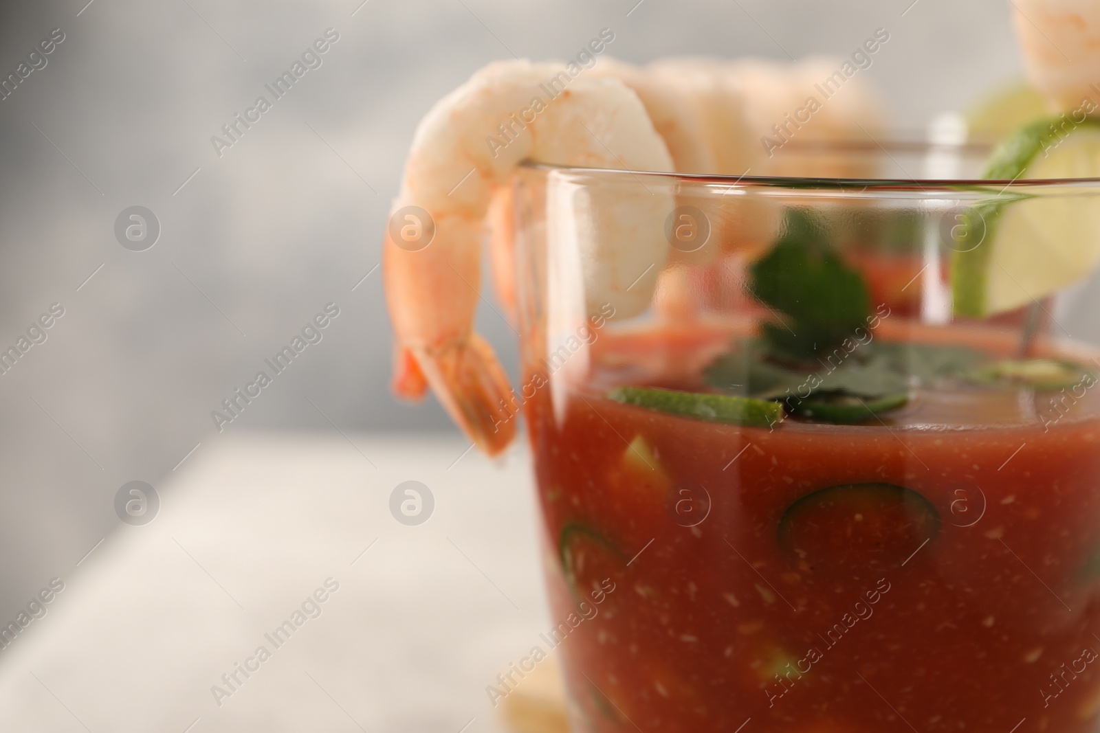 Photo of Tasty shrimp cocktail with sauce in glass on table, closeup. Space for text