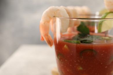 Photo of Tasty shrimp cocktail with sauce in glass on table, closeup. Space for text