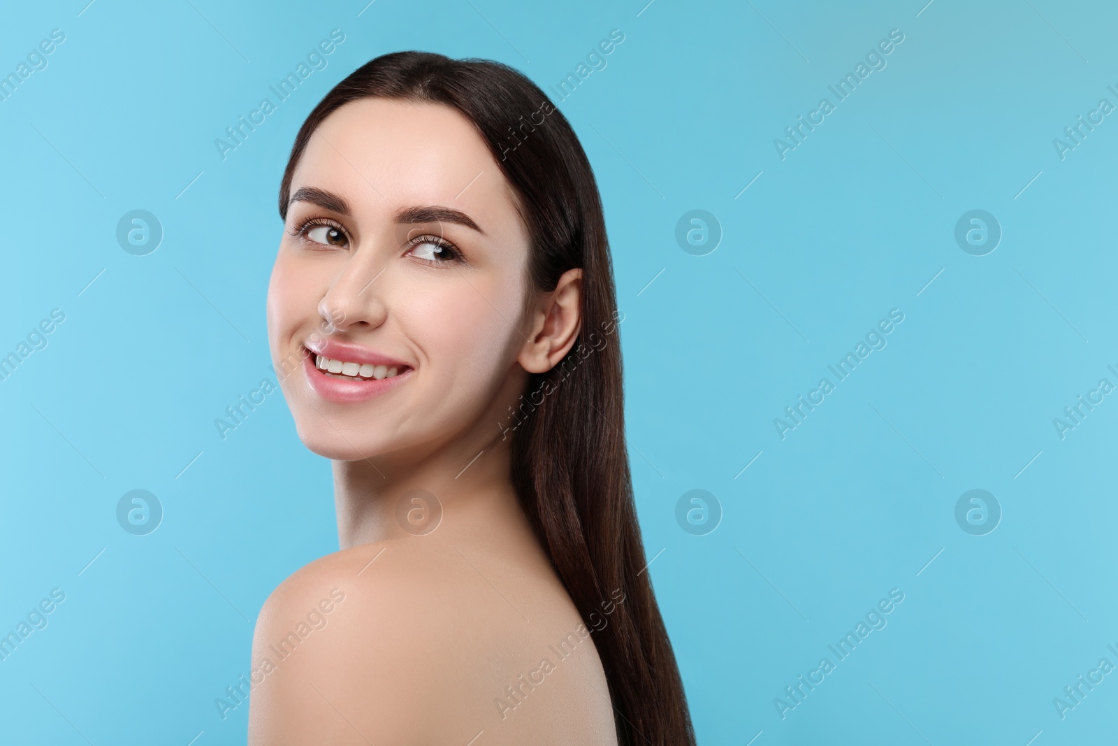 Photo of Portrait of beautiful young woman on light blue background. Space for text