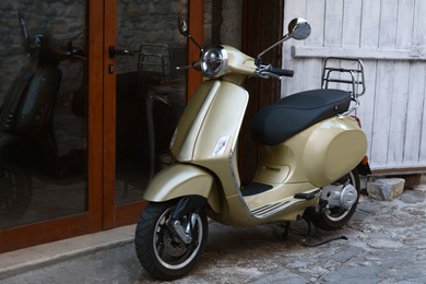 Beautiful scooter parked near building entrance outdoors