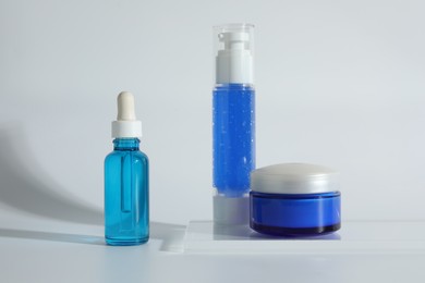 Different containers with cosmetic products on light background