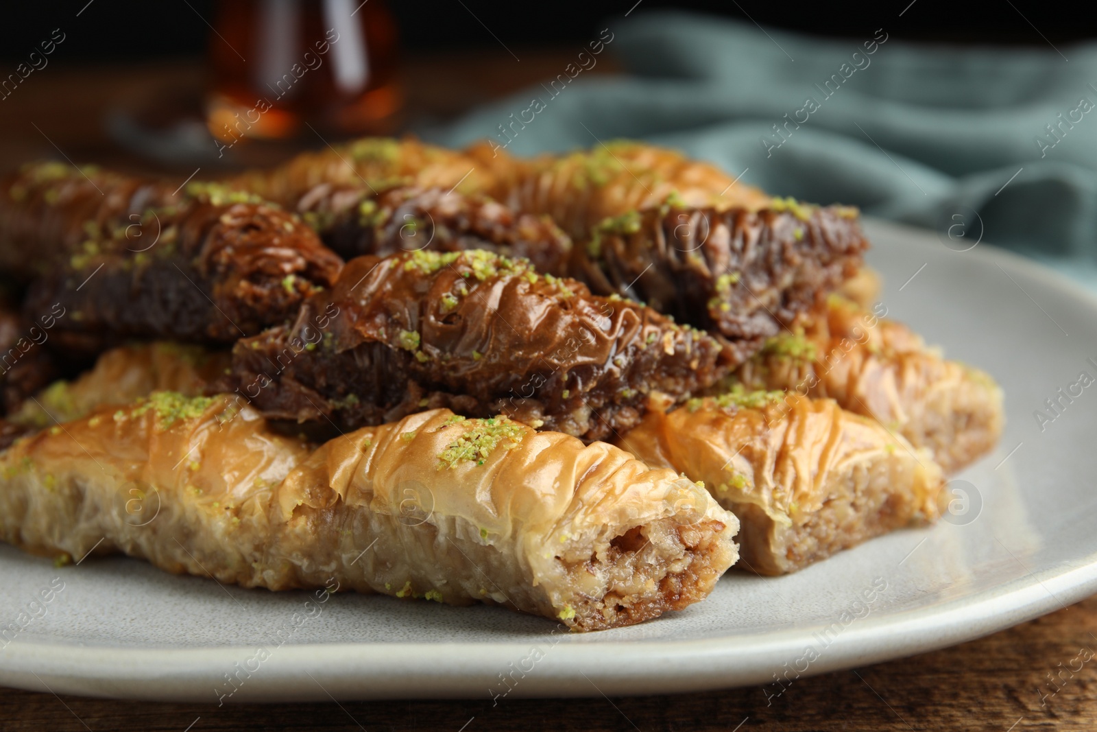 Photo of Delicious baklava with pistachios on wooden table, closeup