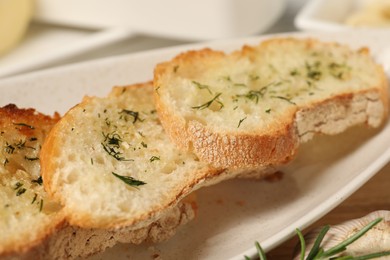 Photo of Tasty baguette with garlic and dill on table, closeup