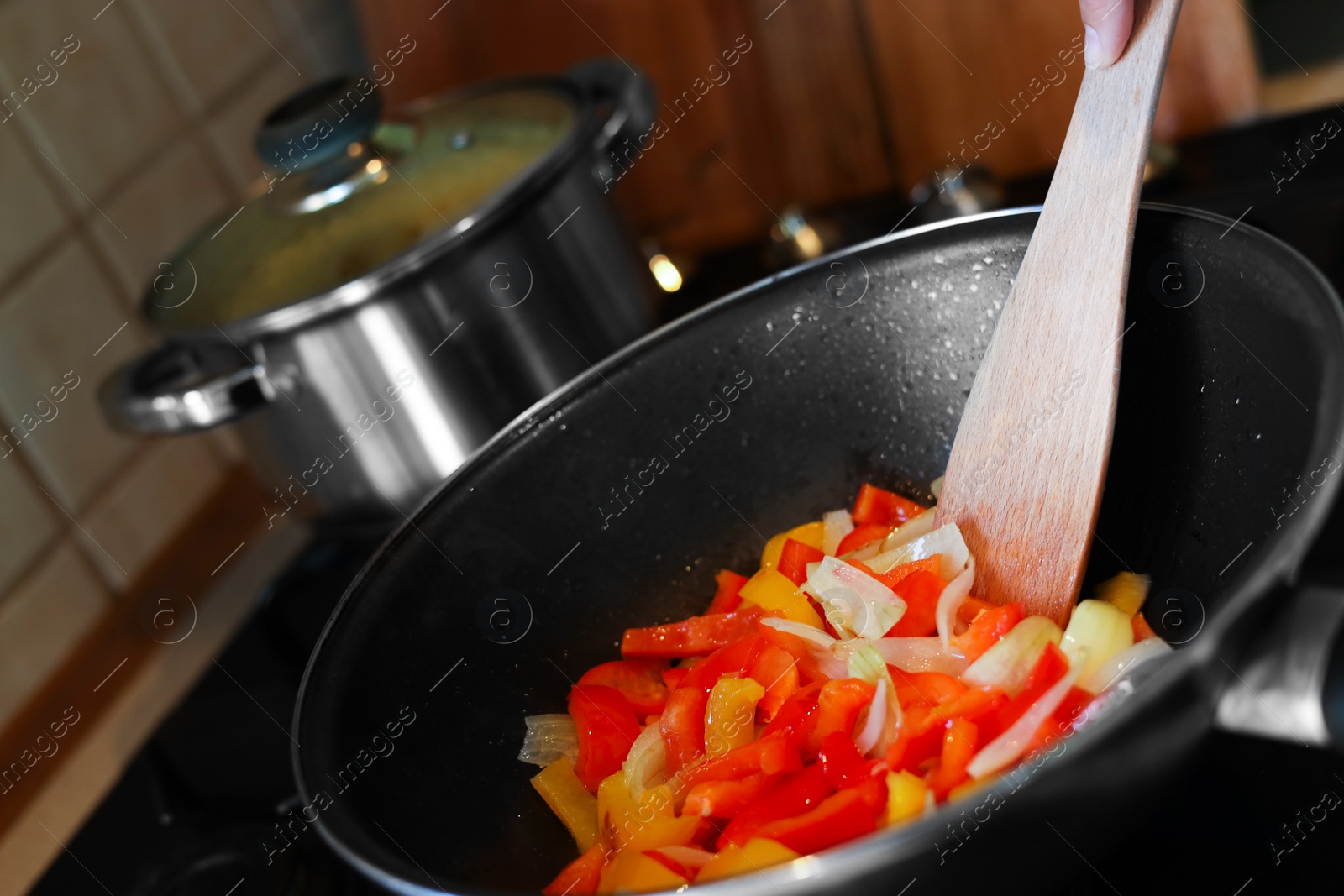 Photo of Cooking fresh vegetables in frying pan on stove, closeup