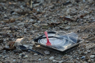 Photo of Used plastic tableware at beach, space for text. Environmental pollution concept