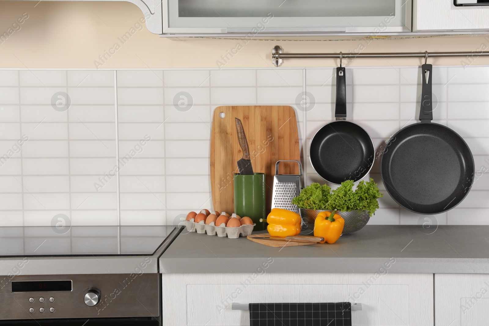 Photo of Set of clean cookware, utensils and products on table in modern kitchen. Space for text