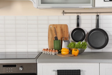 Photo of Set of clean cookware, utensils and products on table in modern kitchen. Space for text