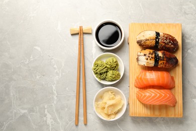 Delicious nigiri sushi served on light grey marble table, flat lay. Space for text