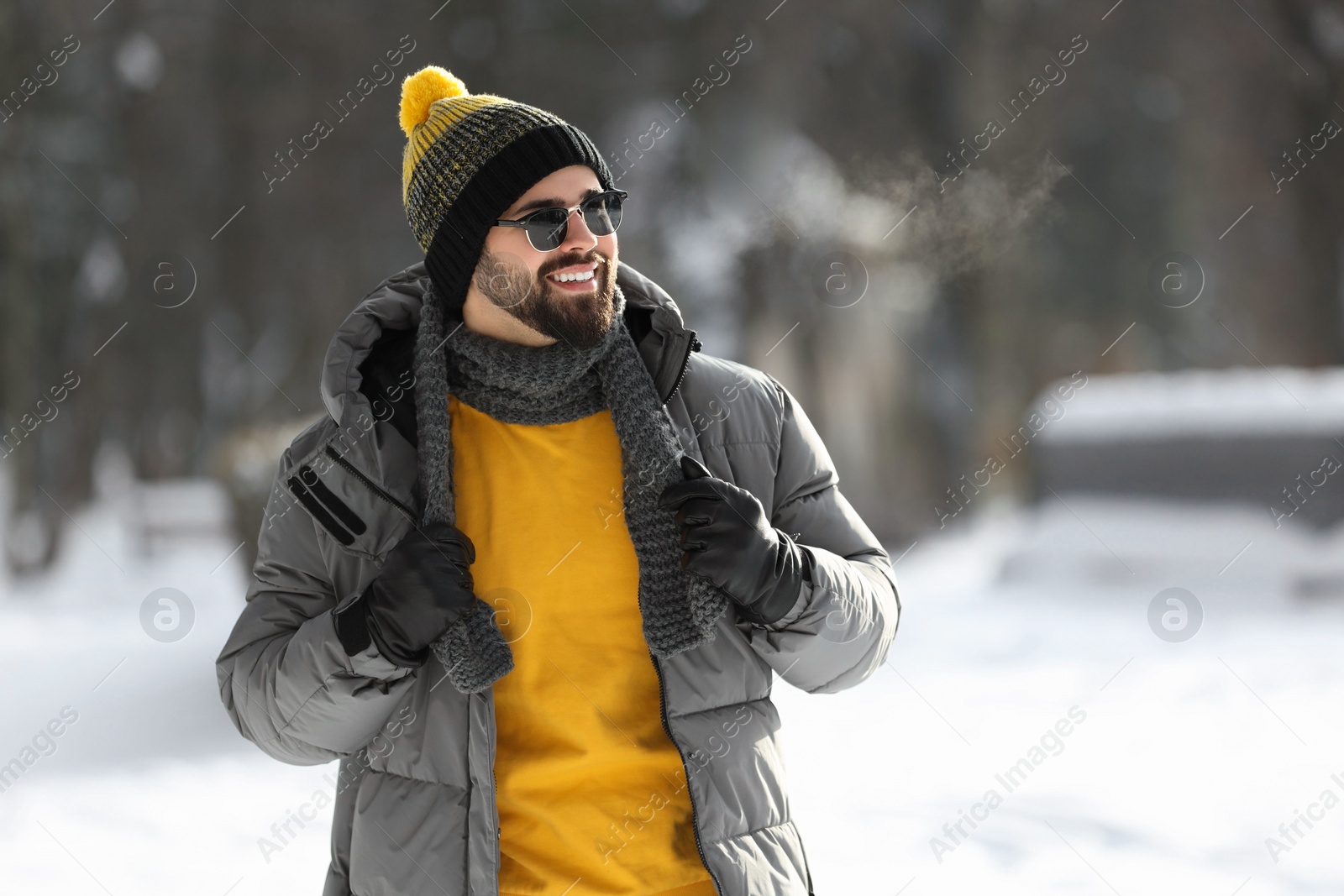 Photo of Portrait of handsome young man with sunglasses on winter day outdoors