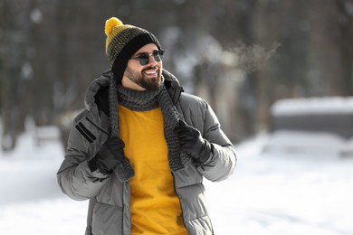 Photo of Portrait of handsome young man with sunglasses on winter day outdoors