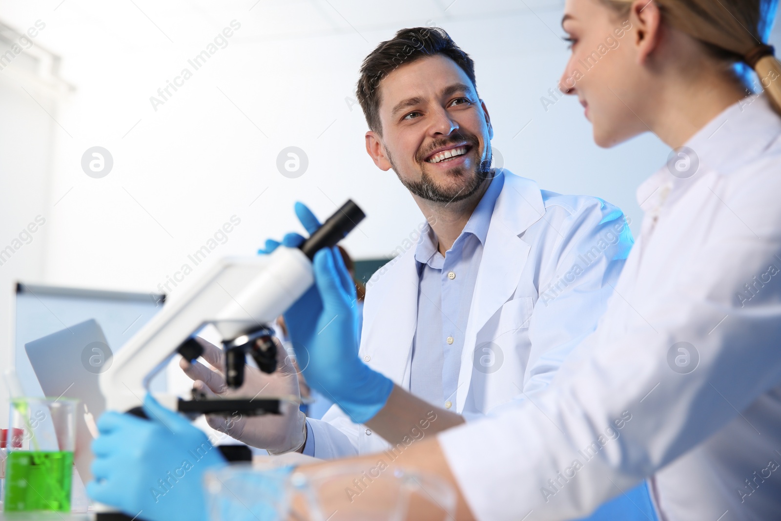 Photo of Scientists working at table in modern chemistry laboratory