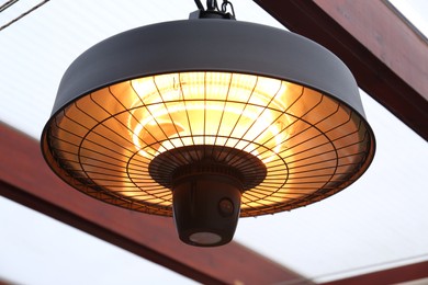 Closeup view of hanging infrared heater indoors