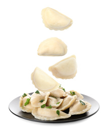 Many tasty dumplings falling on white background