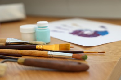 Photo of Many painting tools on wooden table indoors, closeup. Creative hobby