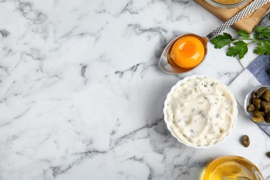 Photo of Tasty tartar sauce and ingredients on white marble table, flat lay. Space for text
