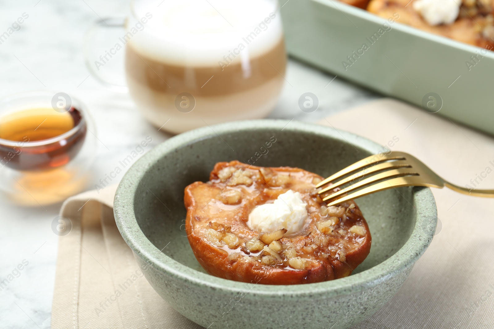 Photo of Tasty baked quince with nuts and cream cheese in bowl on table, closeup