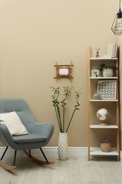 Photo of Stylish room interior with bamboo frame and rocking chair