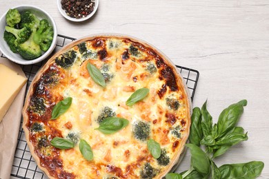 Delicious homemade salmon quiche and ingredients on wooden table, flat lay