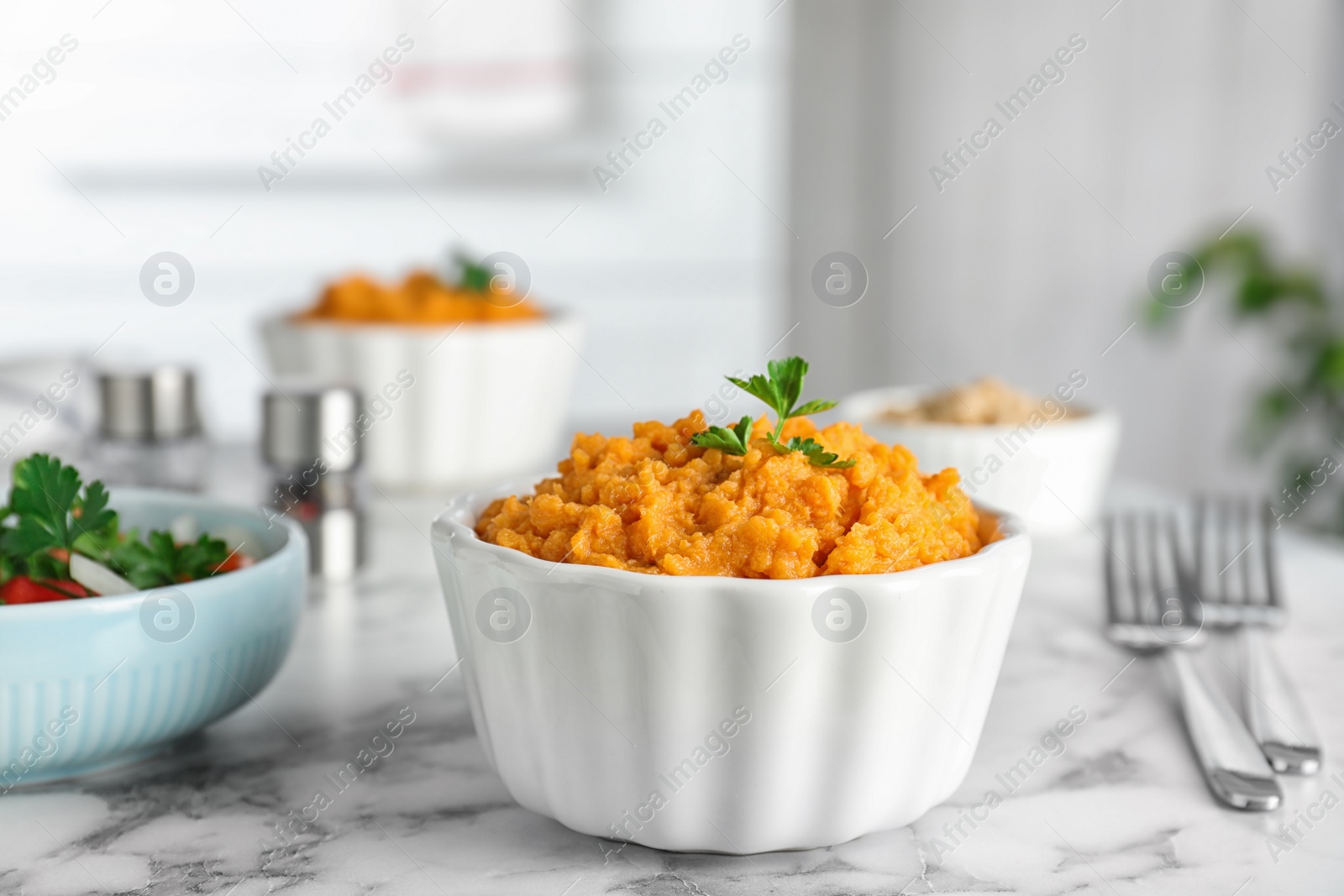 Photo of Bowl of tasty sweet potato puree on marble table