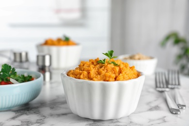 Photo of Bowl of tasty sweet potato puree on marble table