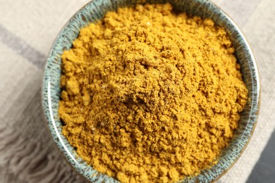 Photo of Dry curry powder in bowl on table, top view