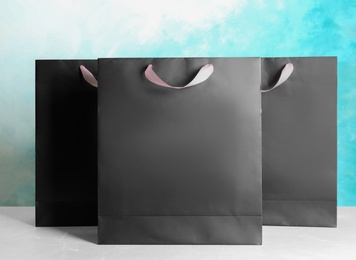 Photo of Paper shopping bags on table against color background. Mock up for design