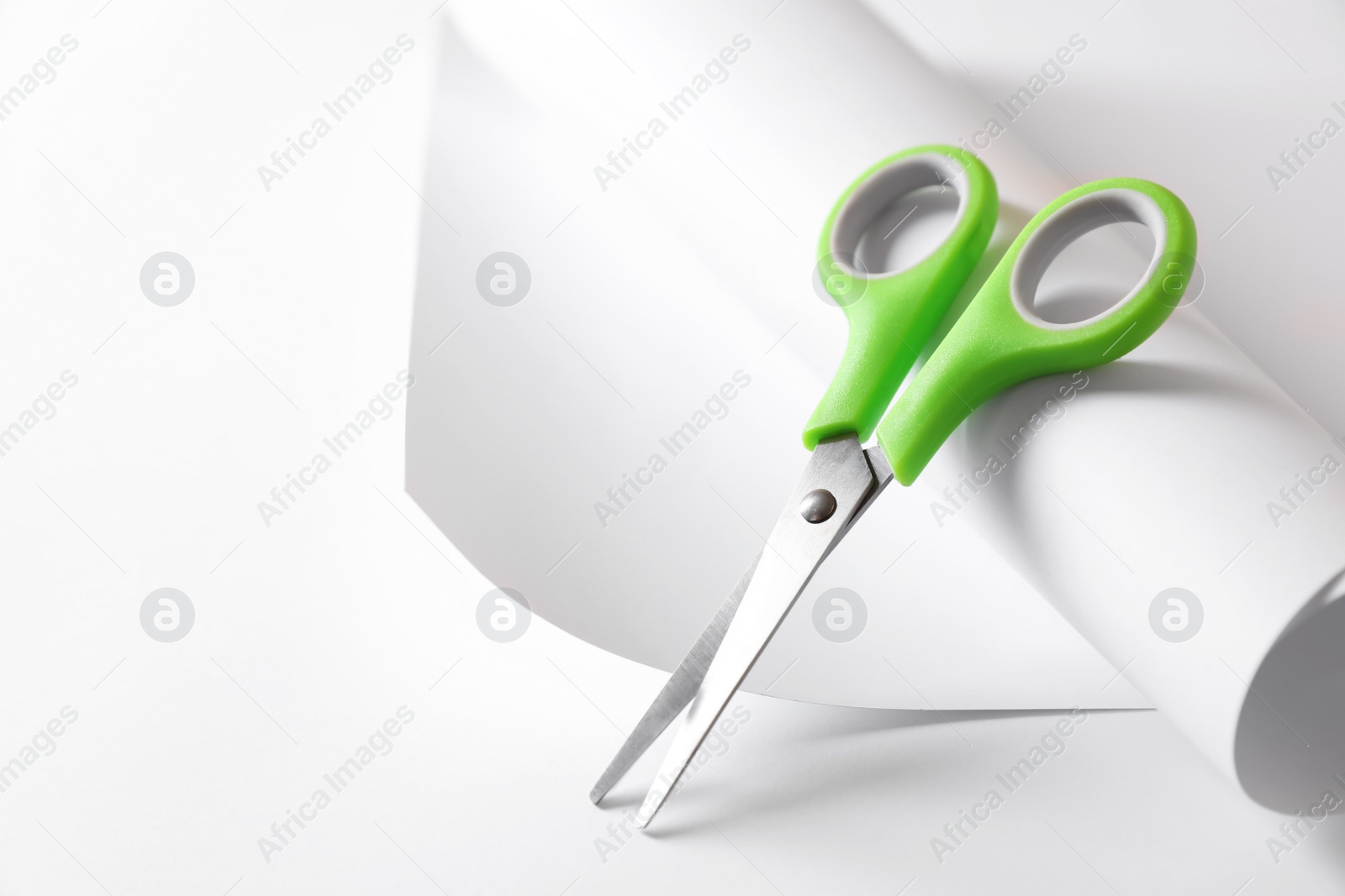 Photo of Green scissors and paper on white background