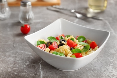 Photo of Bowl with delicious pasta primavera on table