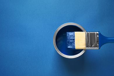 Photo of Can of paint and brush on bright background, top view with space for text. Color of the year 2020 (Classic blue)