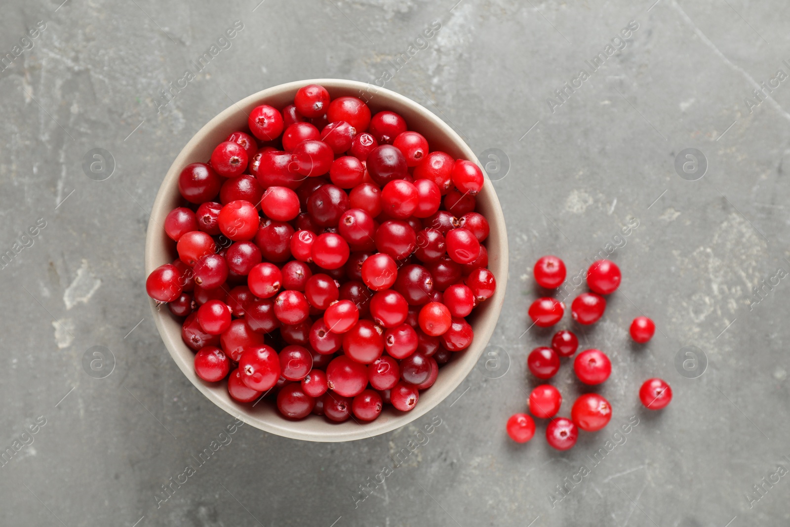 Photo of Cranberries in bowl on light grey table, top view