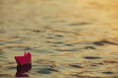 Paper boat floating on water outdoors. Space for text