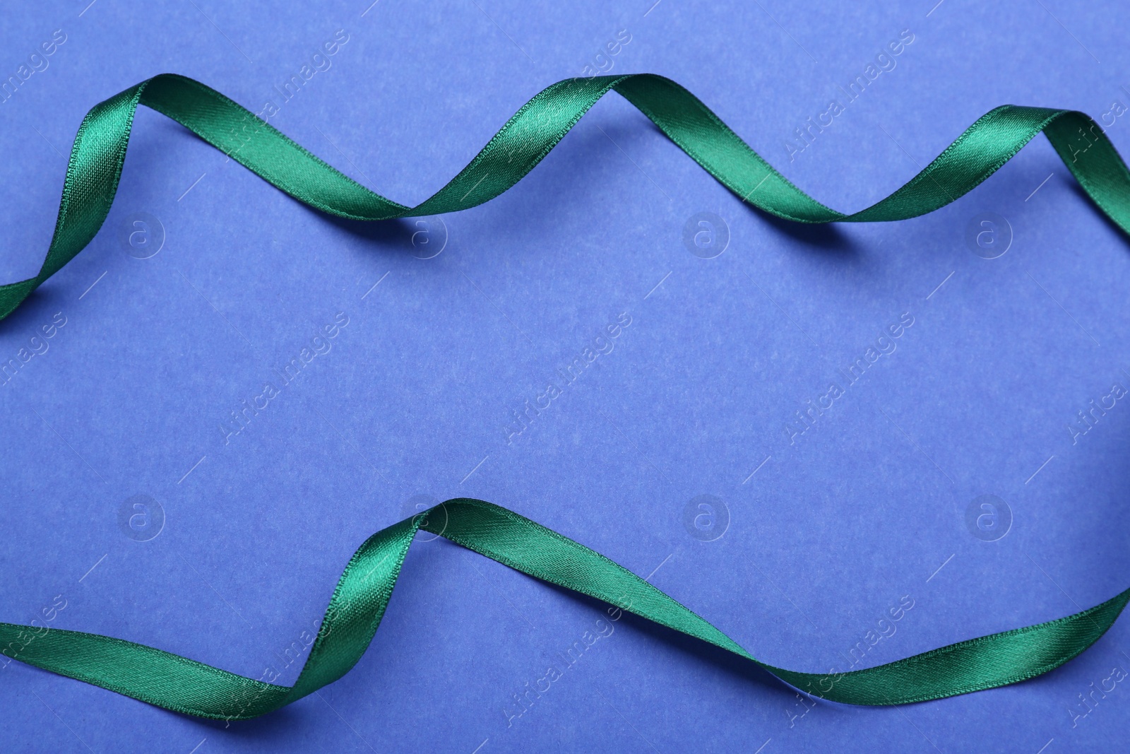 Beautiful green ribbons on blue background, flat lay. Space for text Photo of Beautiful green ribbons on blue background, flat lay. Space for text