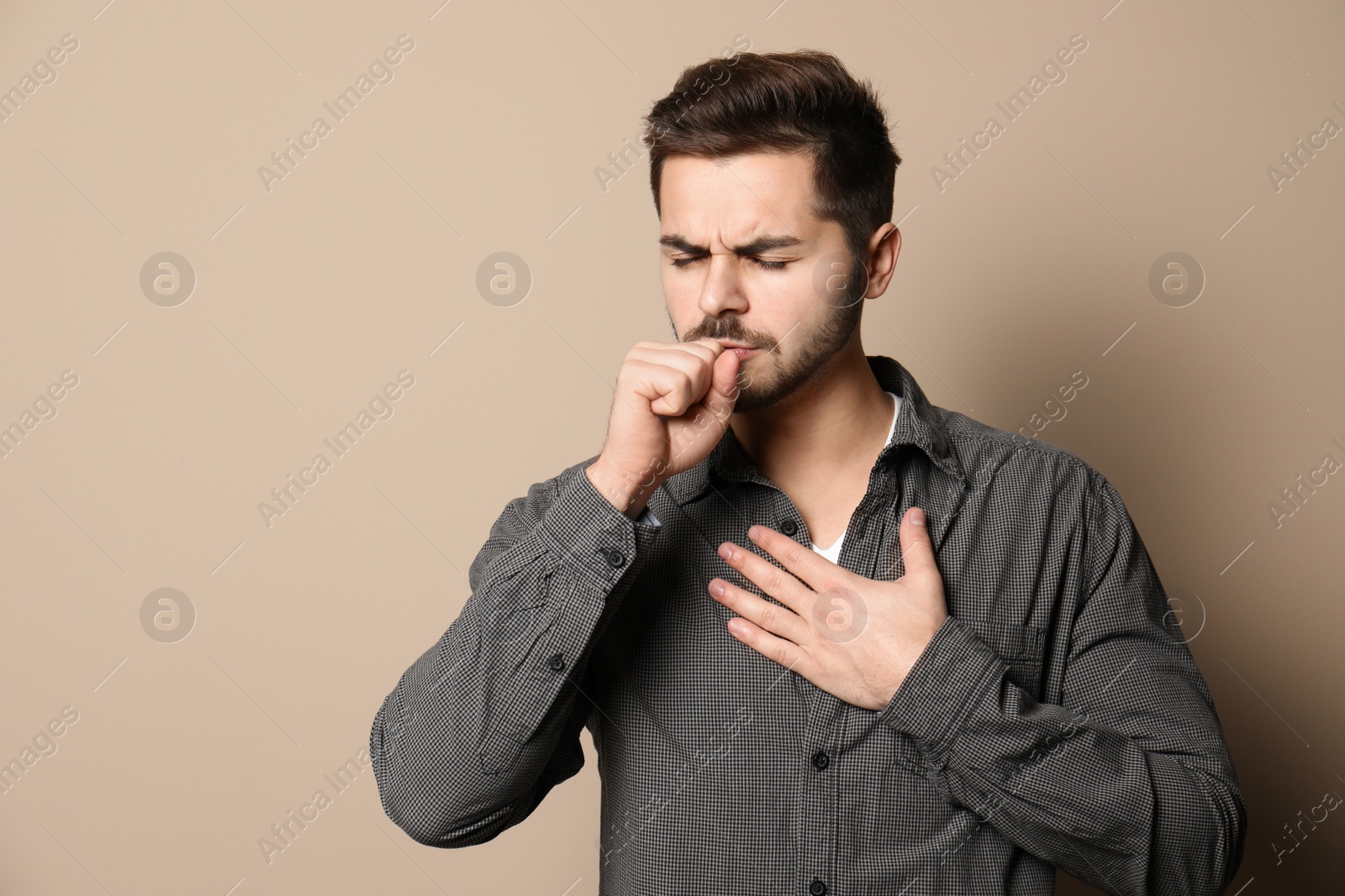 Photo of Handsome young man coughing against color background. Space for text