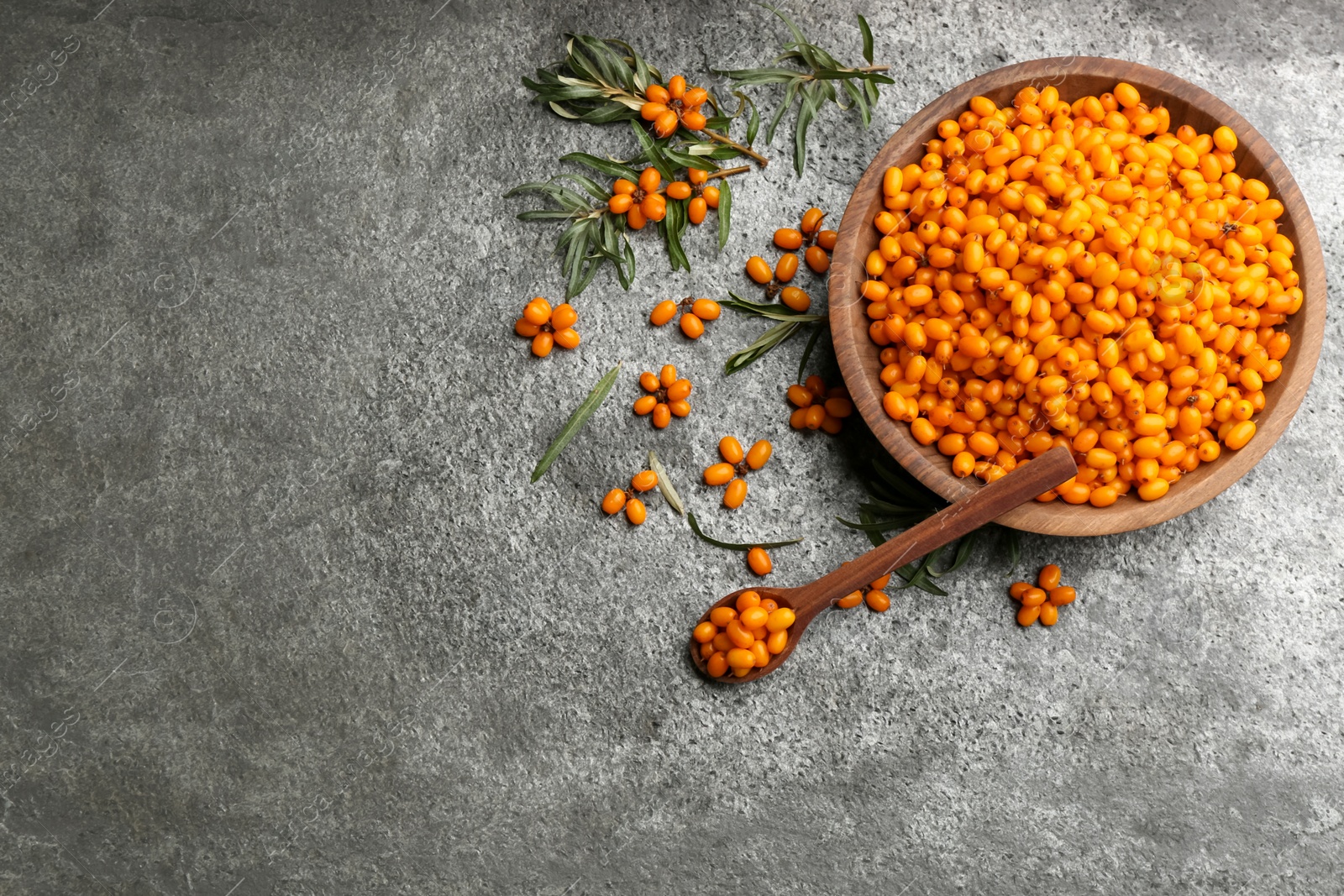 Photo of Fresh ripe sea buckthorn on grey table, flat lay. Space for text