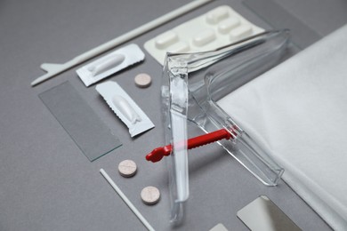 Photo of Sterile gynecological examination kit and medicaments on grey background