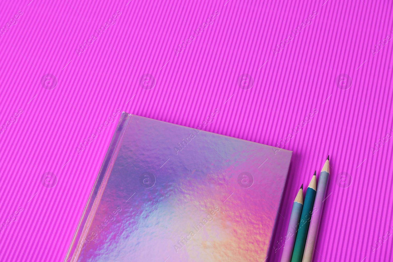 Photo of Beautiful notebook and pencils on color background