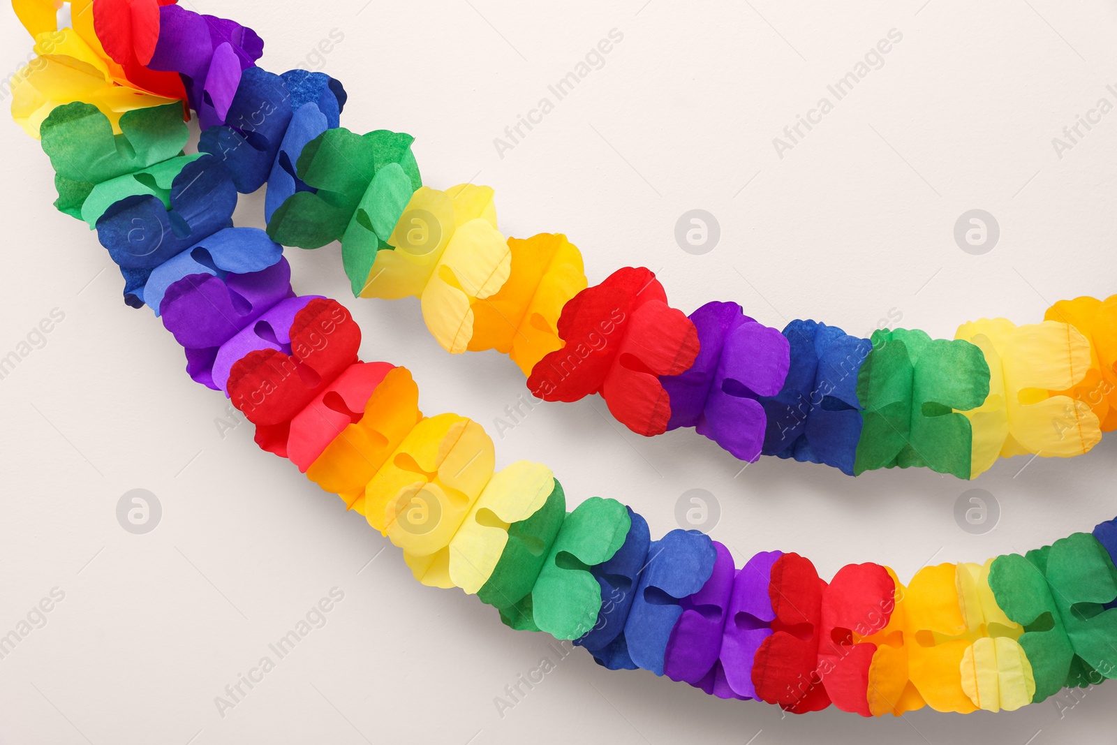 Photo of Rainbow paper garlands on beige background. LGBT pride