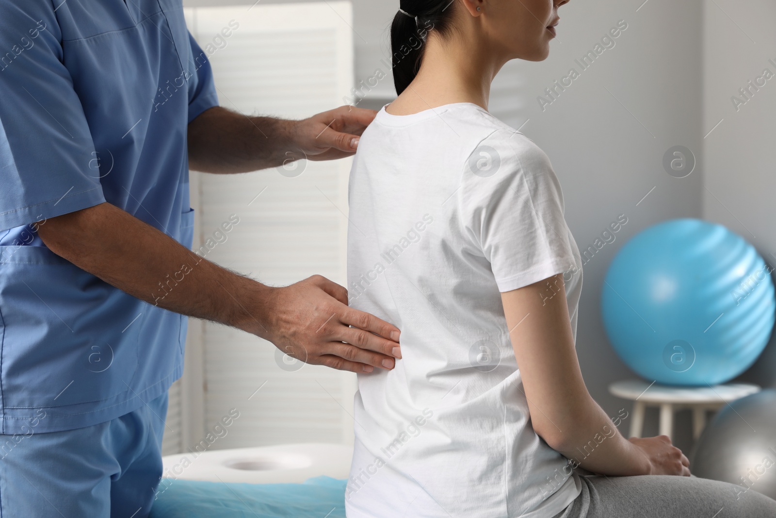 Photo of Orthopedist examining woman's back in clinic, closeup. Scoliosis treatment