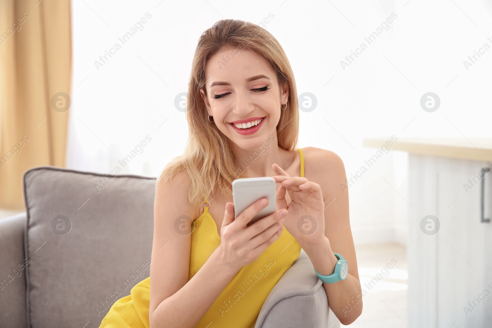 Photo of Young woman using phone indoors