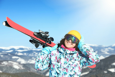 Photo of Young woman with ski equipment in mountains. Winter vacation