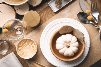 Photo of Autumn table setting with pumpkin and decor on wooden background, flat lay