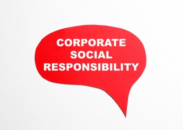 Photo of Red paper sheet with words Corporate Social responsibility on white background, top view