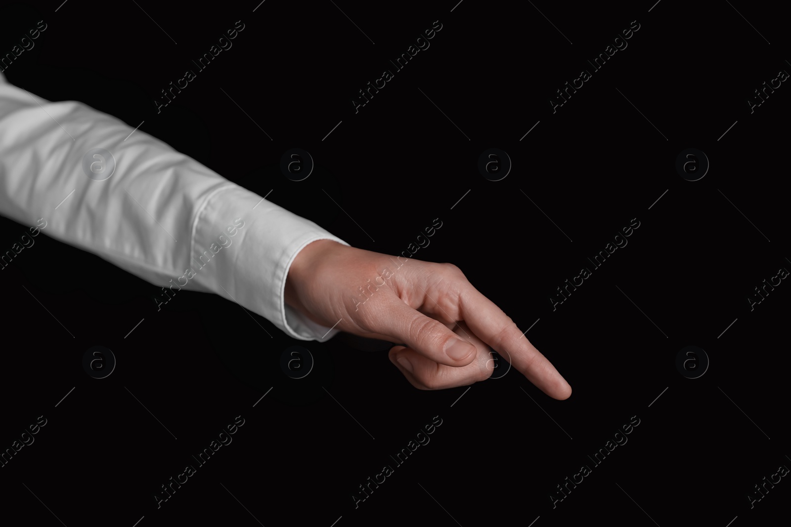Photo of Businesswoman pointing at something on black background, closeup