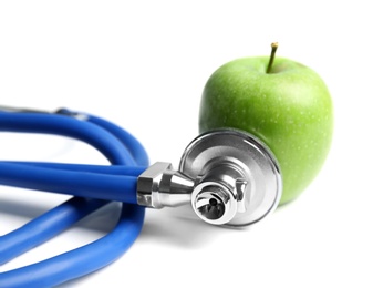 Photo of Stethoscope and apple on light background. Medical equipment