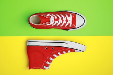 Photo of Pair of new stylish red sneakers on colorful background, flat lay
