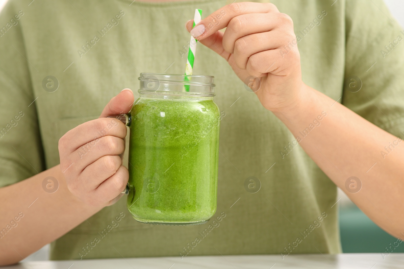 Photo of Woman holding mason jar with delicious smoothie, closeup